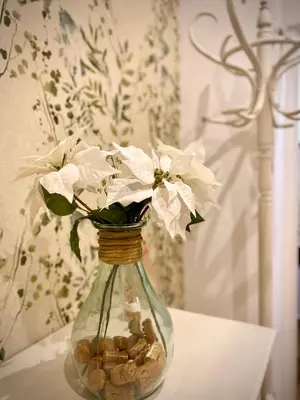 a glass vase with flowers and rocks on a table at Tierra in Valencia