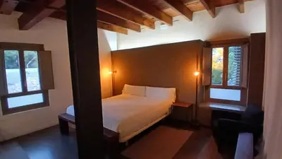 a bedroom with a bed and two windows at Loft en molino rehabilitado in Paterna