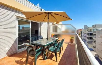a patio table with chairs and an umbrella on a balcony at 2 Bedroom Amazing Apartment In Moncofa in Moncófar
