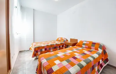 a room with two beds and a table at 2 Bedroom Amazing Apartment In Moncofa in Moncófar