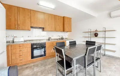 a kitchen with a table and some wooden cabinets at 2 Bedroom Amazing Apartment In Moncofa in Moncófar