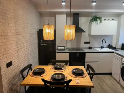a kitchen with a wooden table and black appliances at El refugio del mar in Playa de Mar