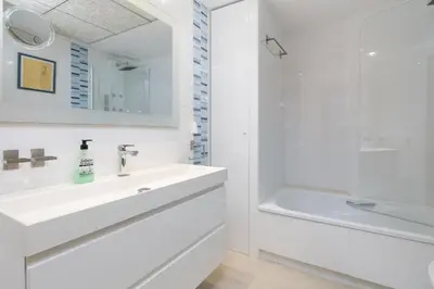 a white bathroom with a sink and a shower at ApartUP Patacona Sunrise Duplex II in Valencia
