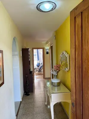 a hallway with a table with a vase of flowers on it at Acogedor Apartamento Cullera 200 metros playa in Cullera