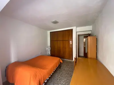 a bedroom with an orange bed and a wooden door at Family flat zona Aragon close to city center and beach in Valencia
