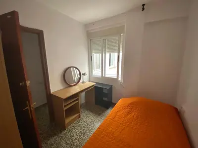 a bedroom with an orange bed and a mirror at Family flat zona Aragon close to city center and beach in Valencia