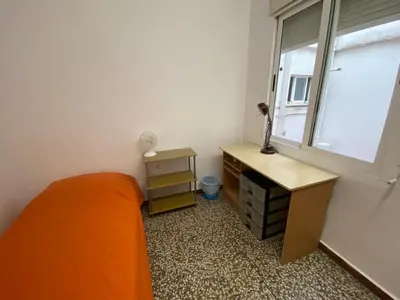 a bedroom with a bed and a desk and a window at Family flat zona Aragon close to city center and beach in Valencia