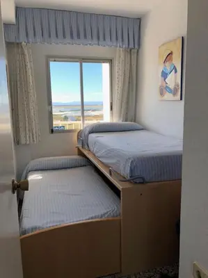 two beds in a small room with a window at A modern House with Perfect Views in Mareny Blau