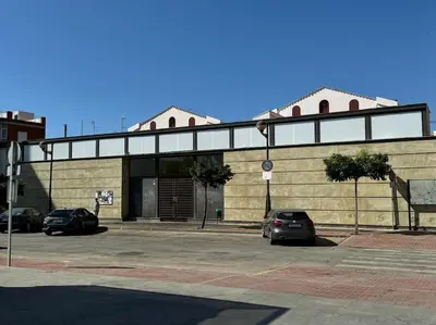a building with two cars parked in a parking lot at Como en casa in Puerto de Sagunto