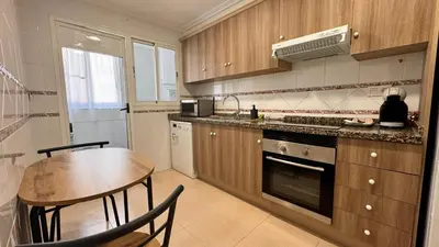 a kitchen with a table and a sink and a stove at Vacaciones en el mar in Puerto de Sagunto