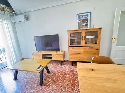 a living room with a tv and a wooden entertainment center at Vacaciones en el mar in Puerto de Sagunto