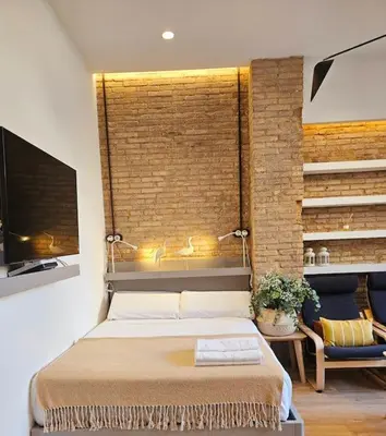 a bedroom with a bed and a brick wall at Tradicional Casa con patio Ruzafa in Valencia
