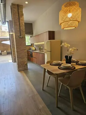 a kitchen with a table with chairs and a refrigerator at Tradicional Casa con patio Ruzafa in Valencia