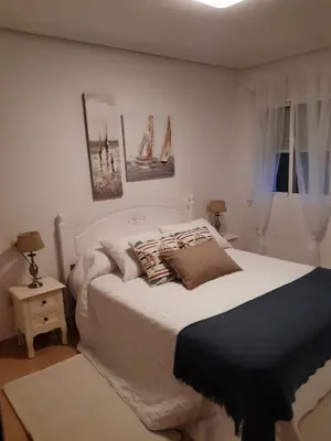 a bedroom with a white bed with pillows on it at El balcón de Alexia, 5 minutos del aeropuerto in Partida de La Cañada