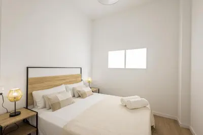 a white bedroom with a large bed and a lamp at 2 rooms 4 Pax, new flat, wifi AC in Valencia