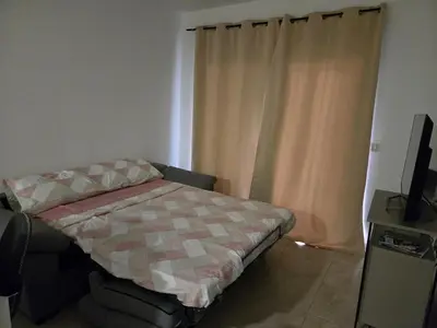 a small bedroom with a bed and a television at Las Jarcias 2C in Moncófar