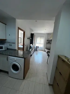 a kitchen with a washing machine and a living room at Cerca del mar, ascensor, descuentos semanales 4 personas in Cullera