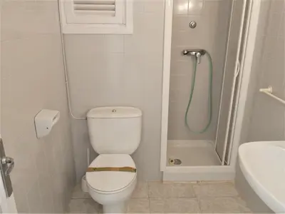 a small bathroom with a toilet and a shower at Amanecer, 1-2 in Cullera