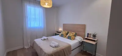 a small bedroom with a bed with towels on it at El Mercado in Puerto de Sagunto