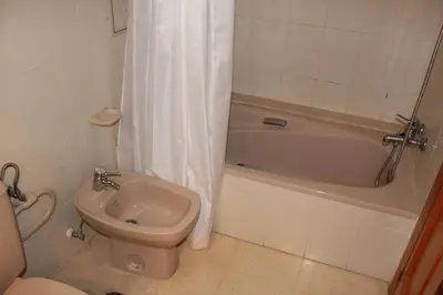 a bathroom with a toilet and a sink and a bath tub at Jardin II Solo Familias Serviplaya in Playa de Xeraco