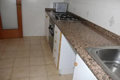 a kitchen with a sink and a counter top at Jardin II Solo Familias Serviplaya in Playa de Xeraco