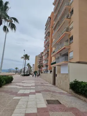 a sidewalk in front of a building next to the beach at Beach view apartment in Cullera in Cullera