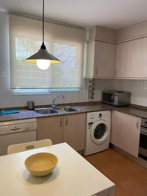 a kitchen with a sink and a washing machine at Agradable adosado con piscina y jardín in Canet de Berenguer