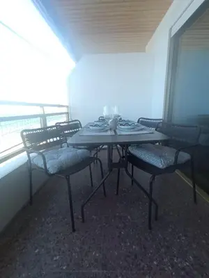 a table and chairs on a balcony with the ocean at Cullera Buena Vista Social Club con piscina y vistas al mar Solo Familias! in Cullera