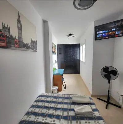 a bedroom with a bed and a flat screen tv at Luminoso ático dúplex con terraza de césped in Montroy