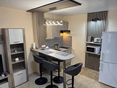 a kitchen with a table and chairs and a refrigerator at Apartamentos Don Quijote Cullera in Cullera