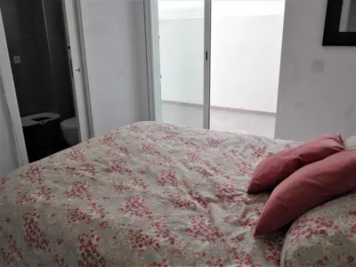a bed with a floral bedspread and two pillows at Bellaterra, BQ-2, BAJO A in Cullera