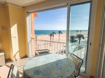 a balcony with a table and a view of the beach at Apartamento primera línea playa San Antonio in Cullera