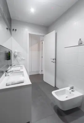 a white bathroom with a sink and a toilet at Mercado Central Suites in Valencia