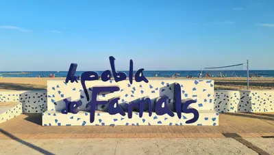 a bench with writing on it on the beach at Vista Mar Apartamento Playa Farnals in Playa Pobla de Farnals