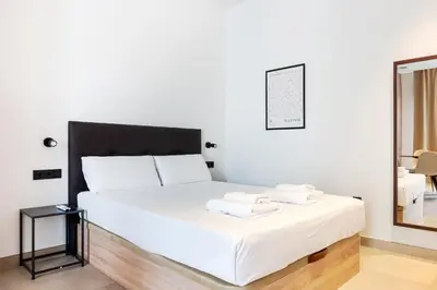 a bedroom with a white bed with a black headboard at VLC HOST - Zapadores in Valencia