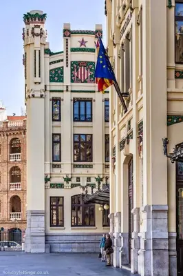 a building with a flag on the side of it at Petite Penthouse with the sunniest terrace in Valencia in Valencia