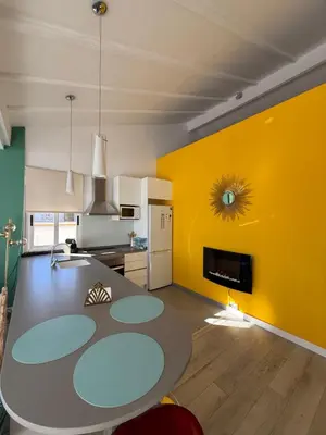 a kitchen with a table and a yellow wall at Petite Penthouse with the sunniest terrace in Valencia in Valencia