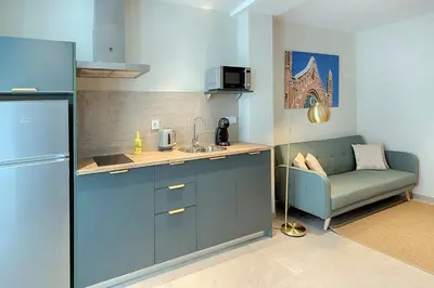 a kitchen with a couch and a sink and a refrigerator at Portal de Ruzafa 1 in Valencia