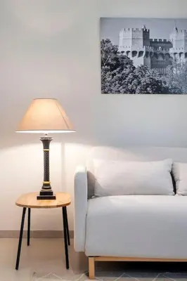 a lamp on a table next to a white couch at Portal de Ruzafa 2 in Valencia