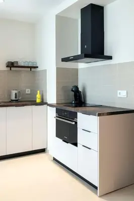a kitchen with white cabinets and a black stove at Portal de Ruzafa 2 in Valencia
