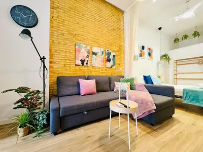 a living room with a couch and a brick wall at Relaxing BeachSide Cabanyal Loft in Valencia