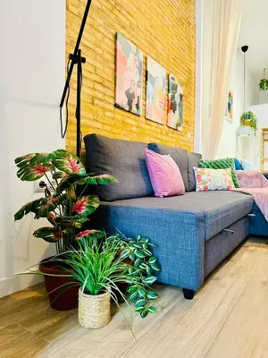 a blue couch in a living room with plants at Relaxing BeachSide Cabanyal Loft in Valencia