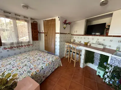 a bedroom with a bed and a kitchen with a sink at Beauty Garden in Cullera