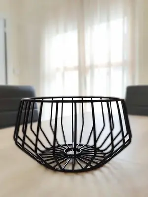 a black wire basket sitting on top of a table at Apartamentos rurales Villamalur in Villamalur
