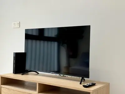 a flat screen tv sitting on a wooden stand at Cabanyal Apto luminoso y playa in Valencia