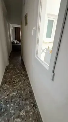 a hallway with a window and a rock floor at Apartamento cerca de la playa in Cullera