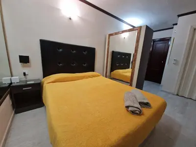 a bedroom with a bed with a yellow blanket and a mirror at Style Apartments City Center in Valencia