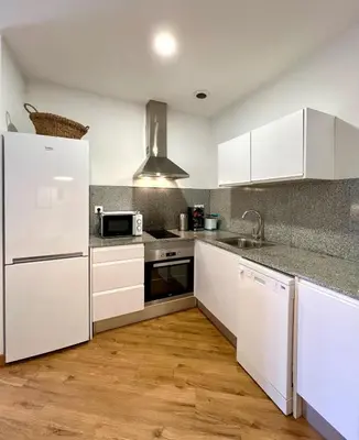 a kitchen with white cabinets and a refrigerator at Apartamentos de Pradas in Valencia