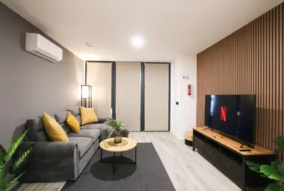 a living room with a couch and a tv at Sweet Suites in Valencia