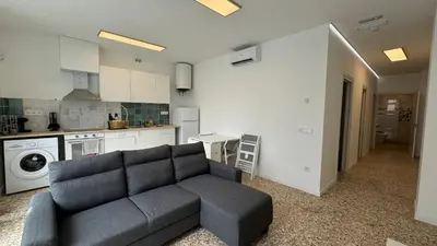 a living room with a couch and a kitchen at Cabañal Retreat in Valencia